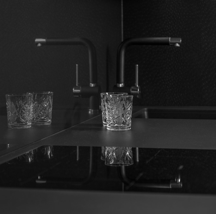 Dark kitchen and sink with crystal glasses
